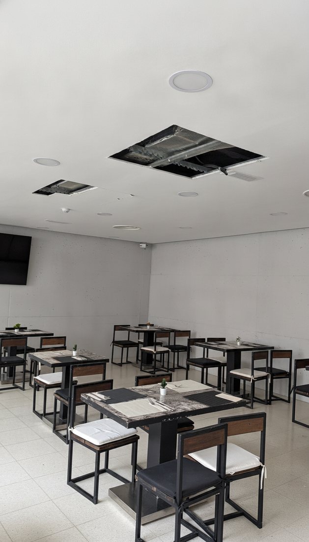 Instalación de conductos de climatización en el falso techo de un local